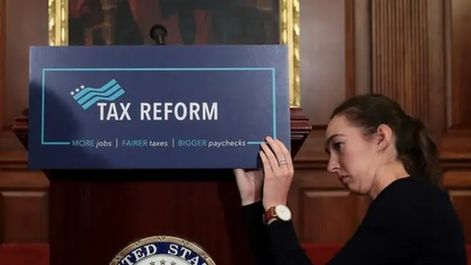 అమెరికా కాంగ్రెస్ భవనంలోని ఒక హాలులో పన్ను సంస్కరణల ప్రణాళిక వేదికను అమరుస్తున్న సహాయకురాలు