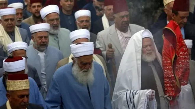 أحد كهنة الطائفة السامرية حاملا لفائف التوراة خلال صلاة في جبل جرزيم، قرب نابلس بالضفة الغربية