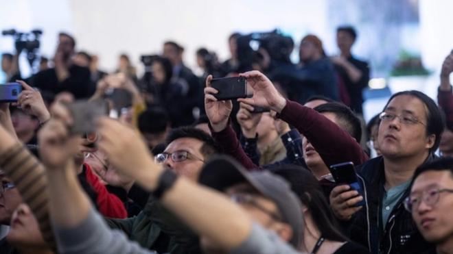 Journalists and guests take pictures during a press conference and launch of new 5G Huawei products