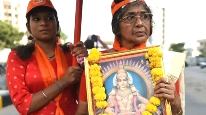 ભગવાન અયપ્પાની તસવીર સાથે શ્રદ્ધાળુ મહિલા