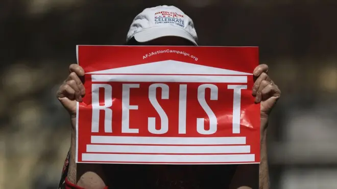 Seorang peserta Pawai Perempuan memegang poster menentang RUU Layanan Kesehatan Amerika yang disokong Presiden Donald Trump, dalam aksi di Washington, DC, pada 8 Maret lalu.