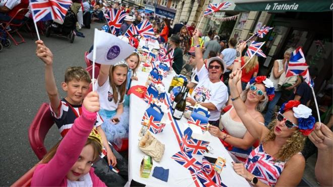 Participants wave flags during the town's street party on 3 June 2022 in Swanage, Dorset