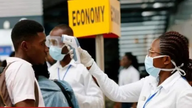 Afisa wa afya akiwapima watu viwango vya joto mwilini