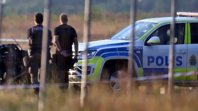 Police officers observe a small aircraft that crashed at Orebro Airport, Sweden