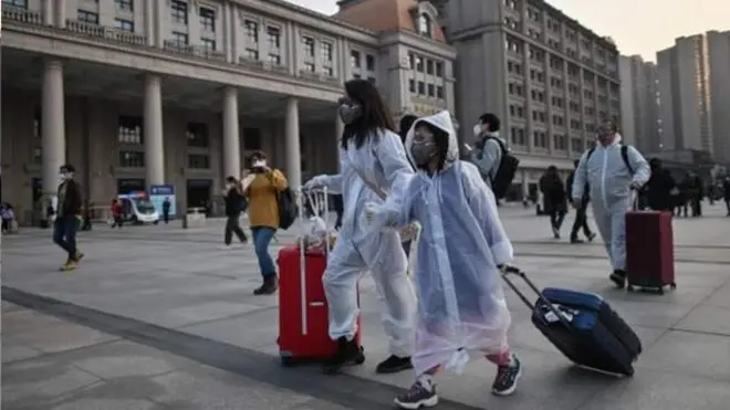 武漢解封後身穿防護服的市民前往車站