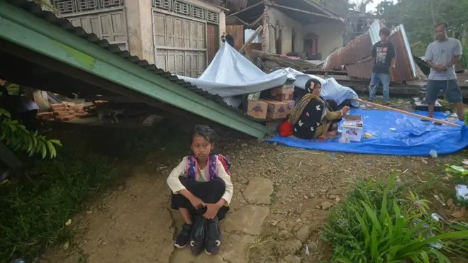 Warga duduk di halaman rumahnya yang rusak akibat gempa di Jorong Pinagar, Nagari Aua Kuning, Kabupaten Pasaman Barat, Sumatera Barat, Jumat (25/2/2022)