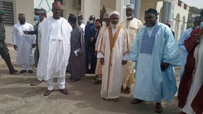Niger State Governor, Alhaji Abubakar Sani Bello [wear white agbada to di left] dey stand with Sheik Ahmad Gumi [wey dey middle to di right] on Friday morning 19 February, 2021.