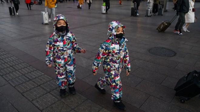 Twins wearing masks on a shopping street in Beijing