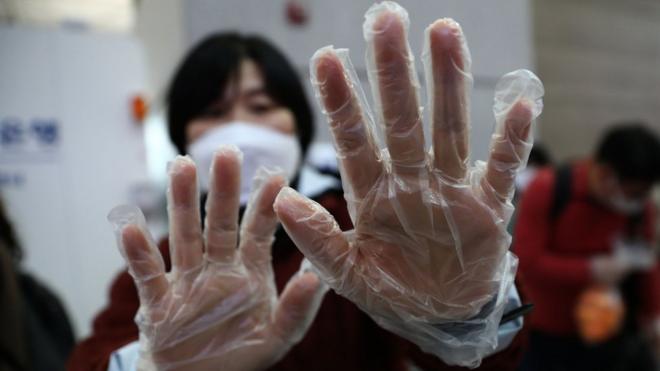 A South Korean woman wears a plastic glove at Incheon International Airport