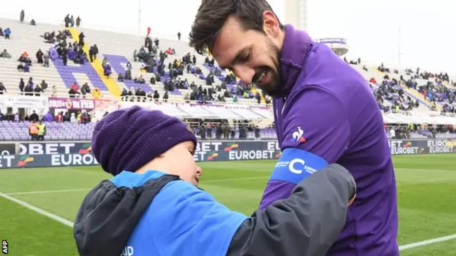 Seorang bocah memasang ban kapten pada lengan Davide Astori sebelum Fiorentina menghadapi Chievo pada laga Serie A, 25 Februari. Pertandingan itu adalah yang terakhir untuk Astori.