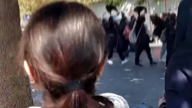 Screengrab of video posted on social media showing schoolgirls marching along a street in Gohardasht, Karaj, Iran, while waving their headscarves in the air and chanting "death to the dictator" (3 October 2022)