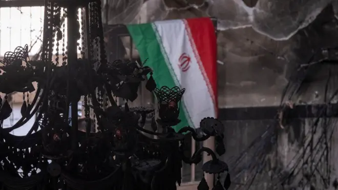 يرفرف العلم الإيراني على جدار المسجد الأقصى، الذي احترق خلال الاحتجاجات المناهضة للحكومة في شرق طهران، إيران، في 21 يناير/كانون الثاني 2026. 