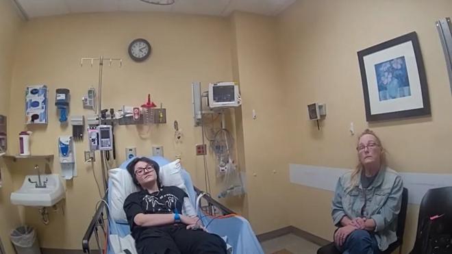 Adolescente em cadeira de hospital ao lado da mãe