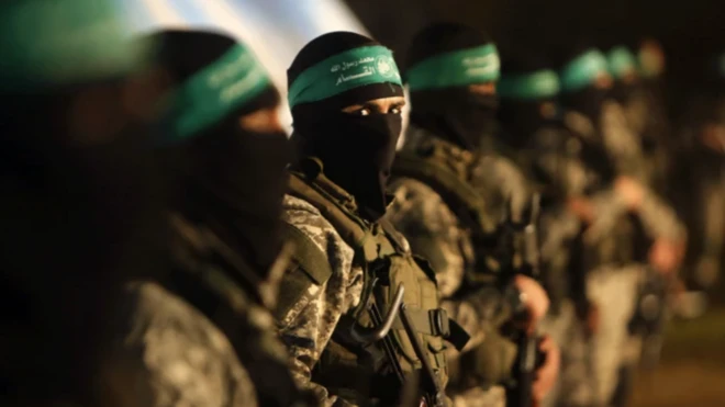 Hamas üyeleri yan yana duruyor, bir maskeli militan kameraya bakıyor