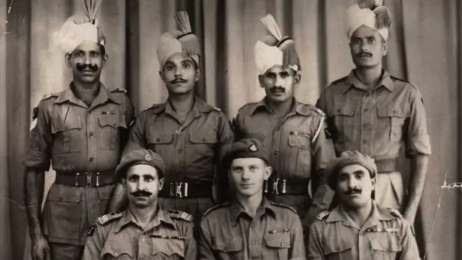 کیپٹن رابن رولینڈ اس تصویر میں درمیان میں بیٹھے ہیں، یہ تصویر سنہ 1945 میں بنکاک میں لی گئی تھی اور ان کے ساتھ ان کی رجمنٹ کے ساتھی ہیں