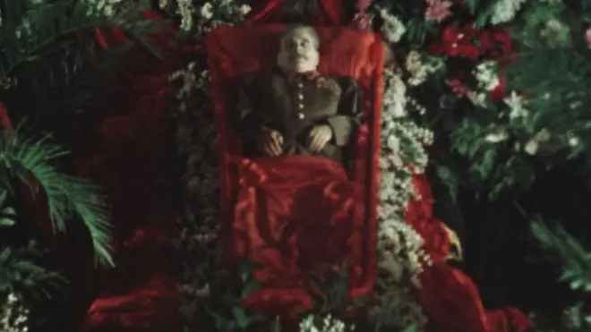 Установленный для прощания в Колонном зале Дома Союзов и утопающий в цветах гроб с телом Сталина. Кадр из фильма.