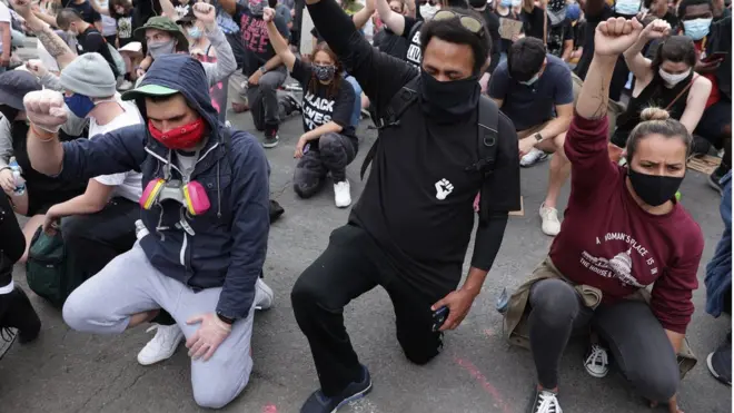 متظاهرون ضد العنصرية جاثون على ركبة واحدة وبرفعون "القبضة السوداء"