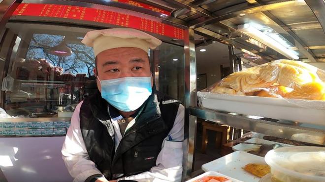 Beijing shopkeeper wearing a mask
