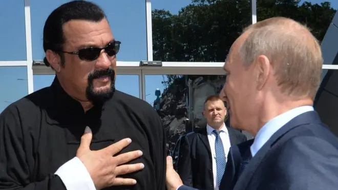 Russian President Vladimir Putin (R) speaks with US action movie actor Steven Seagal (L) at the Russia's first ever Eastern Economic Forum
