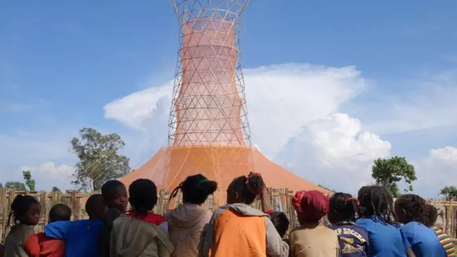 Niños frente a una torre de Warka Water