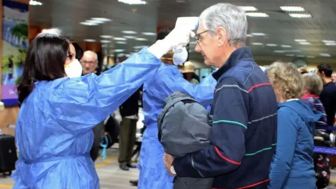 قياس درجة حرارة سائحين في مطار القاهرة