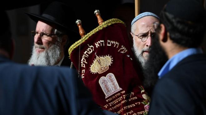 Un hombre sostiene una Torá durante una ceremonia en el patio de la nueva Sinagoga de Regensburg durante su inauguración el 27 de febrero de 2019