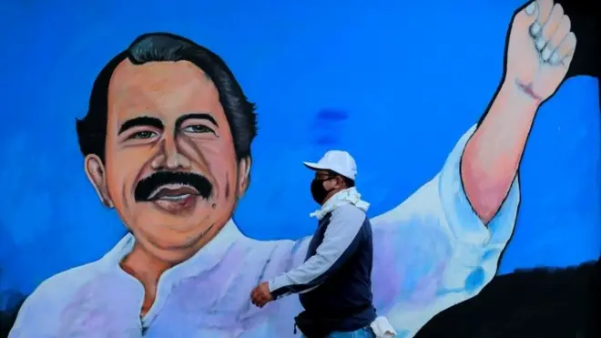 A man walks by a mural depicting Nicaraguan President Daniel Ortega, in Managua