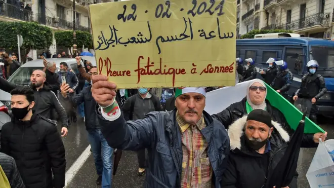 متظاهرون يرفعون لافتة كتب عليها "ساعة الحسم لشعب الجزائر"