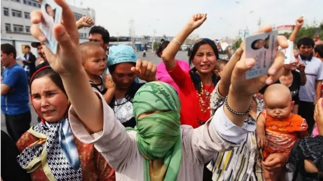 Những người biểu tình Uighur hồi năm 2009 cầm thẻ căn cước của thân nhân bị giam giữ