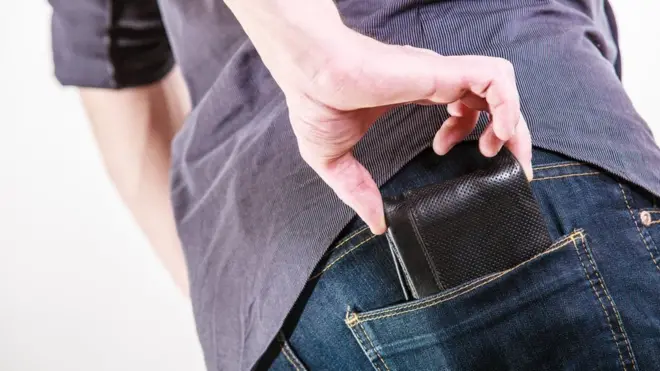 ખિસ્સામાં પર્સ રાખતી એક વ્યક્તિ