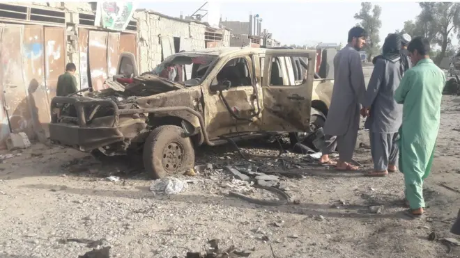 غیرنظامیان در کنار یک خودرو ارتش افغانستان که در درگیریهای ۲۴ ساعت گذشته منهدم شده است.