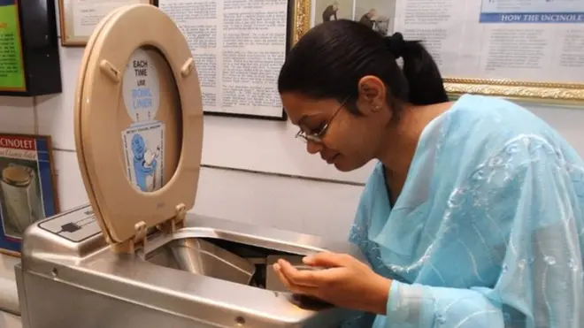 An employee of the Sulabh International Museum of Toilets demonstrates a toilet that incinerates waste at the press of a button at the museum in New Delhi