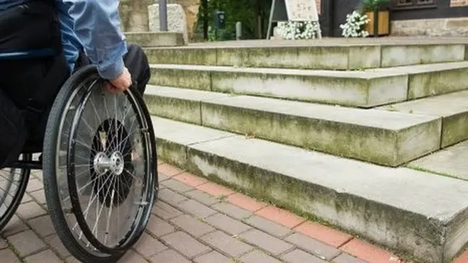 Nogironlik aravachasidagi inson va zinapoyalar