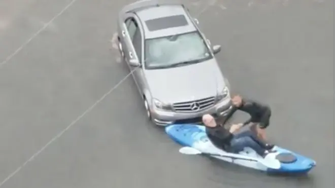 Чоловіка, чия машина застрягла посеред затопленої вулиці, евакуюють на каное