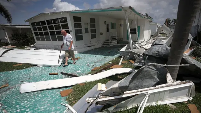 شخص يتفقد آثار الإعصار أمام منزله في فلوريدا