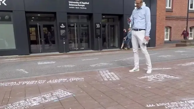 Warga memotret ''cuitan kebencian'', bagian dari proyek seni ''#HEYTWITTER'' yang dibuat Shahak Shapira di depan markas Twitter di Hamburg, Jerman, pada 4 Agustus.