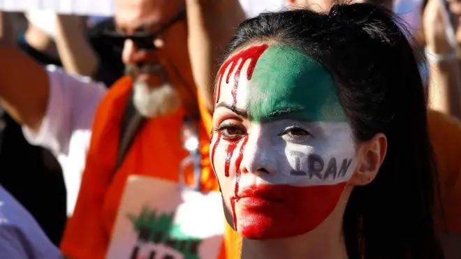 Pengunjuk rasa menghiasi wajahnya dalam demo memprotes kematian Mahsa Amini di Roma, Italia, 29 Oktober 2022.