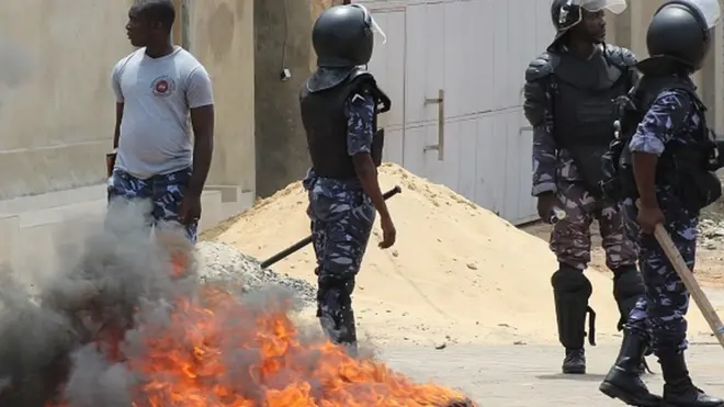 Les forces de sécurité du Togo près d'un pneu incendié par des manifestants.