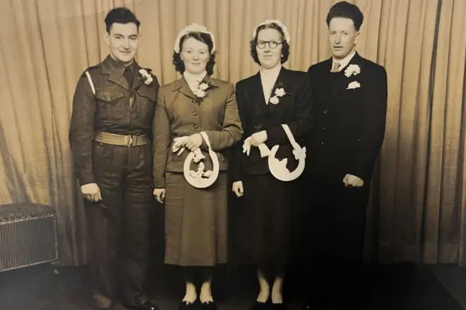 Dois casais de pé em foto de família