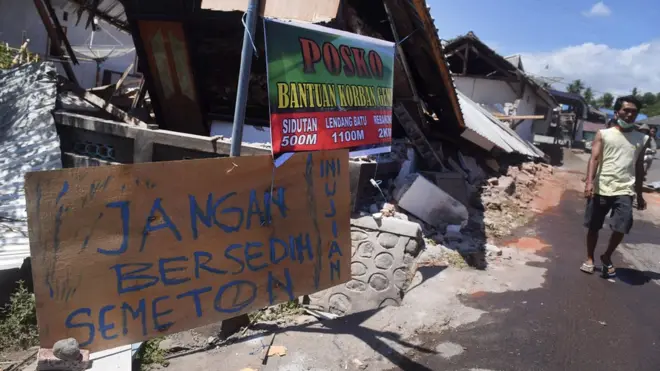 Tulisan pengungsi korban gempa bumi dipasang di sebuah potongan kayu di sekitar lokasi tempat pengungsian darurat di Kayangan, Lombok Utara, NTB, Minggu (12/8). Masih terdapat pengungsi yang belum mendapat bantuan karena sulitnya akses untuk menjangkau lokasi pengungsi.