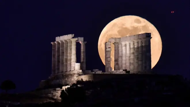 The Moon rises behind the ancient Temple of Poseidon near Athens, Greece. Photo: 26 May 2021