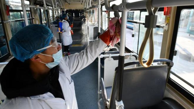 中国的防疫人员对公共汽车等交通工具消毒