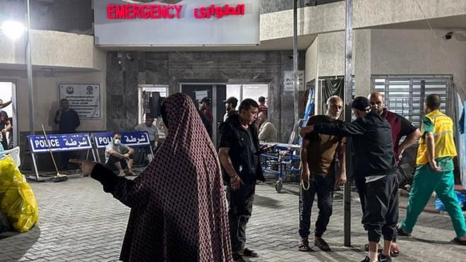 People stand outside the emergency ward of Al-Shifa hospital in Gaza City