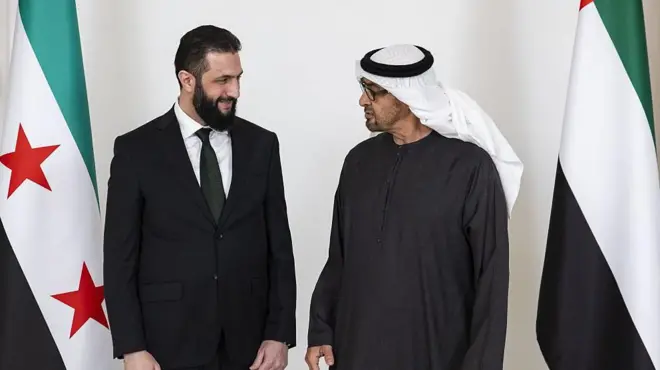 احمد شرع در کنار محمد بن زاید رئیس امارت و پرچم‌های دو کشور