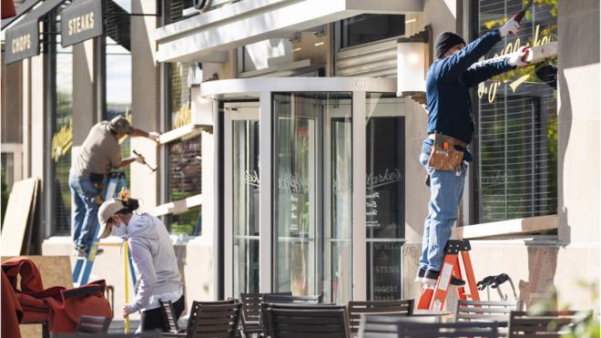 workers board up windows at a Washington restaurant ahead of election day