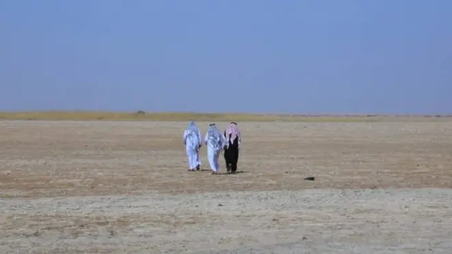 أشخاص يسيرون فوق بحيرة ساوة التي باتت أرضا جدباء