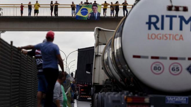 Caminhoneiros e caminhões paradosvalores da aposta da mega senaestrada; ao fundo,valores da aposta da mega senapassarela, apoiadores do presidente seguram bandeira com fotovalores da aposta da mega senaBolsonaro