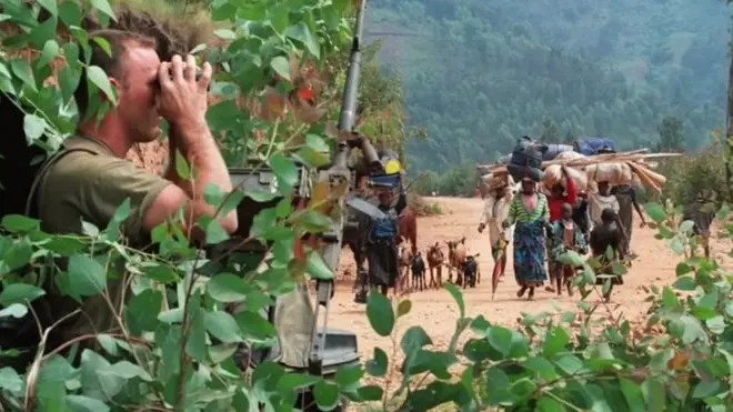 На этом снимке 1984 года французский солдат наблюдает за беженцами, бегущими от убийств на западе Руанды