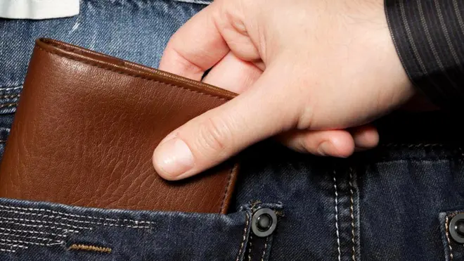 Рука, вытаскивающая из чужого кармана бумажник