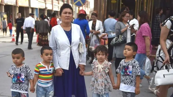 चीन के उत्तर-पश्चिमी प्रांत शिनजियांग में एक वीगर महिला अपने बच्चों के साथ (फ़ाइल फ़ोटो)